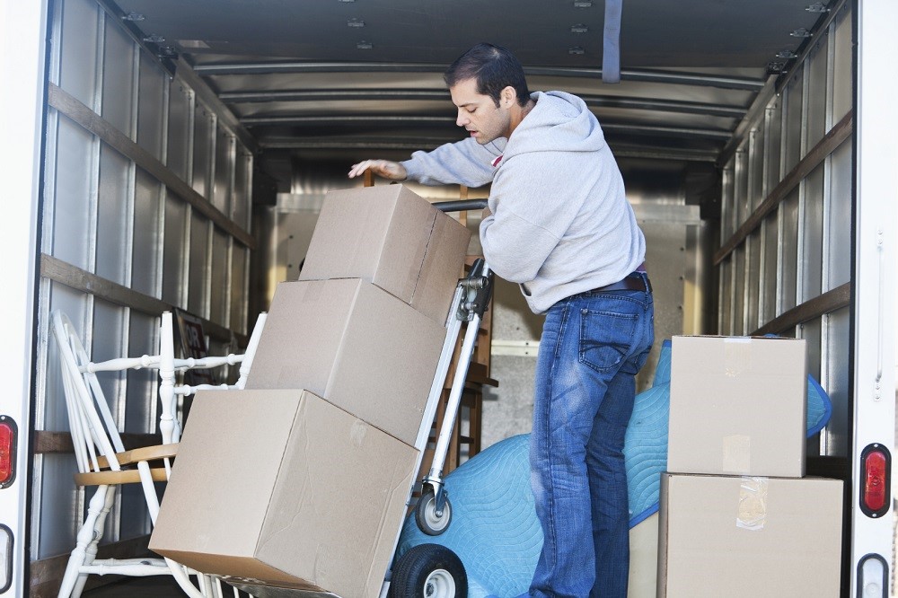 Man in moving truck Mid adult man (30s) standing in moving truck, moving boxes.