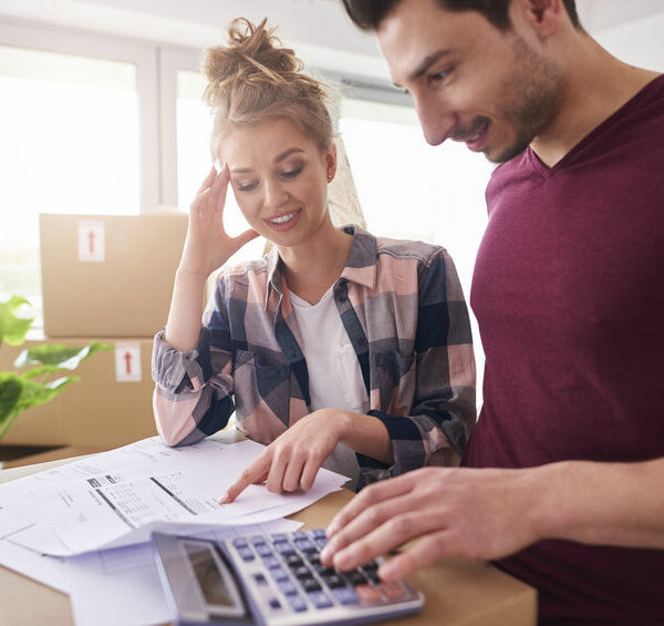 Worried couple examining expenses after moving into new house Worried couple examining expenses after moving into new house