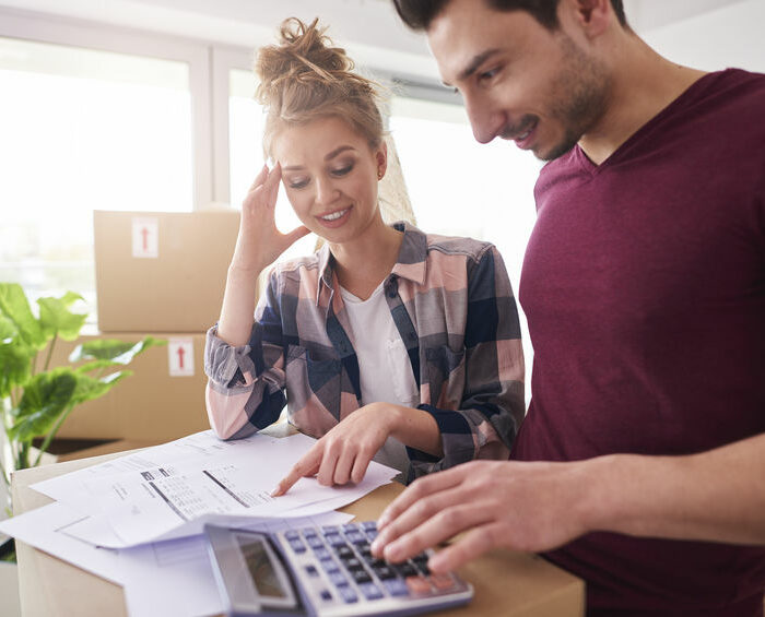 Worried couple examining expenses after moving into new house Worried couple examining expenses after moving into new house