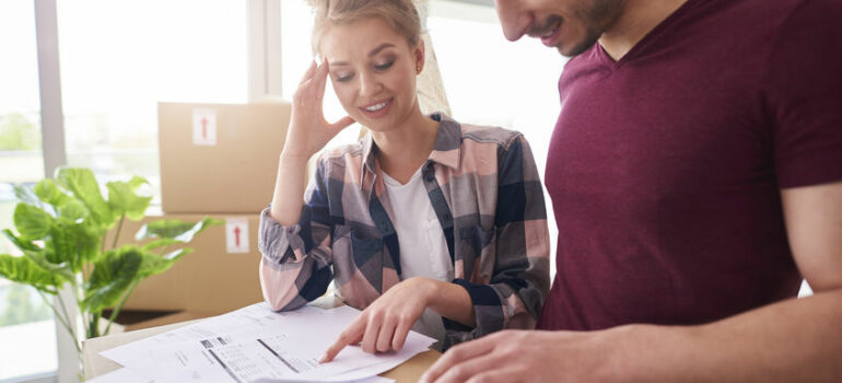 Worried couple examining expenses after moving into new house