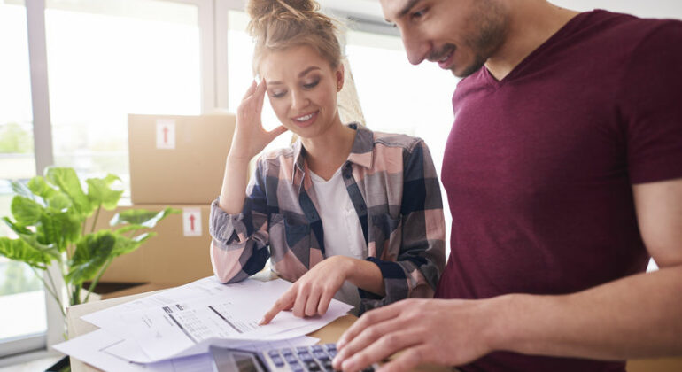 Worried couple examining expenses after moving into new house